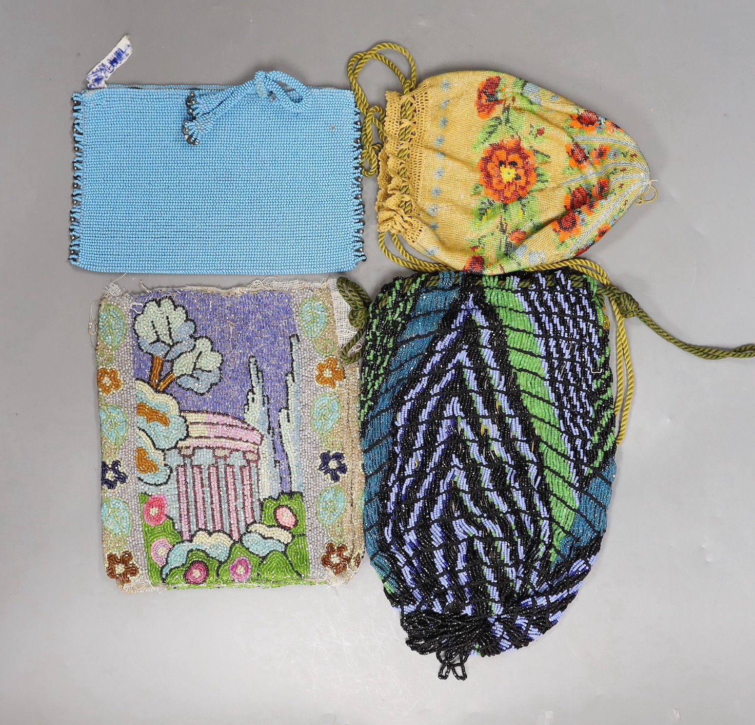 A late 19th century floral bead worked drawstring bag, a later jazz age beaded bag, a turquoise plain bead bag with zip and an unlined bead bag with a classical scene, (4)